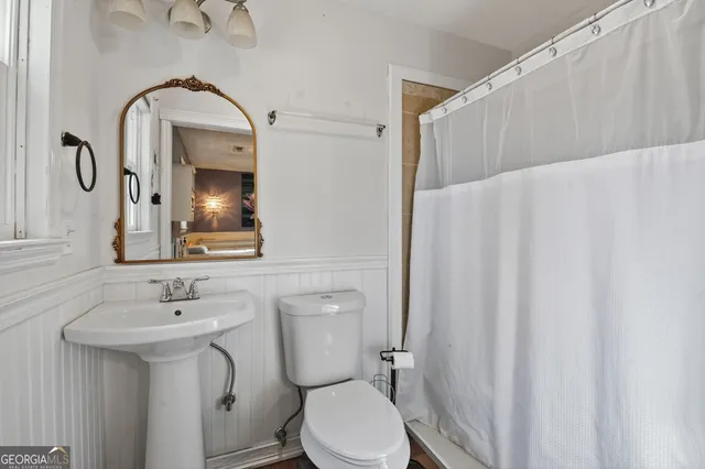 a bathroom with a toilet sink and mirror
