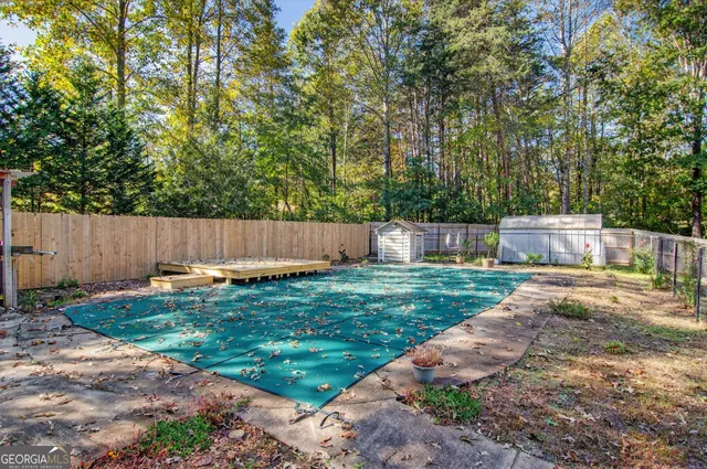 a backyard with a table and chair and wooden fence