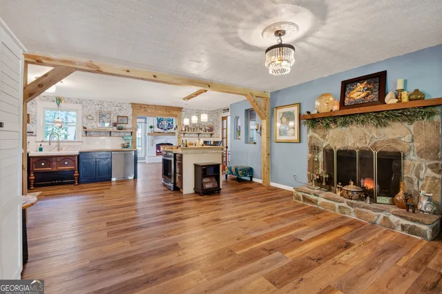 a view of a living room with furniture a fireplace and wooden floor