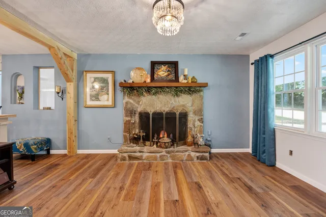 a view of an empty room with a fireplace and a window