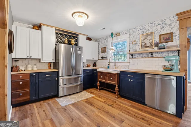 a kitchen with stainless steel appliances granite countertop a refrigerator and a stove top oven