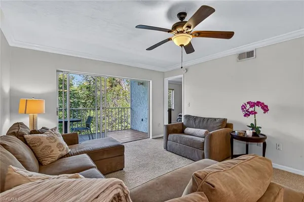 a living room with furniture ceiling fan and a window