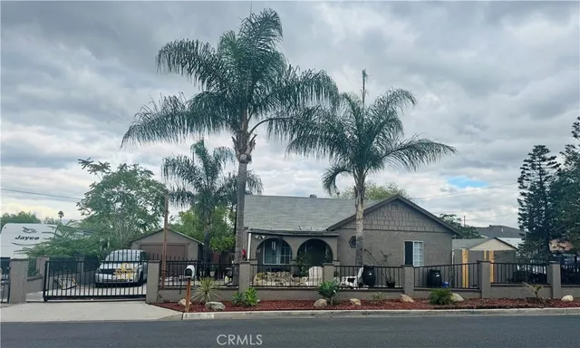 a front view of a house with palm trees