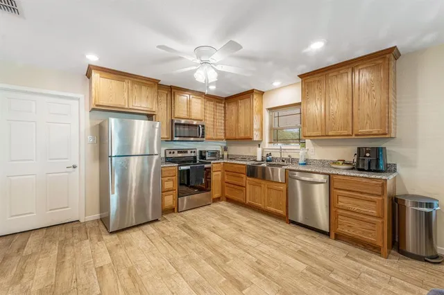 a kitchen with granite countertop stainless steel appliances and wooden cabinets