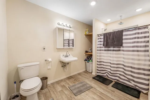 a bathroom with a toilet a sink and mirror