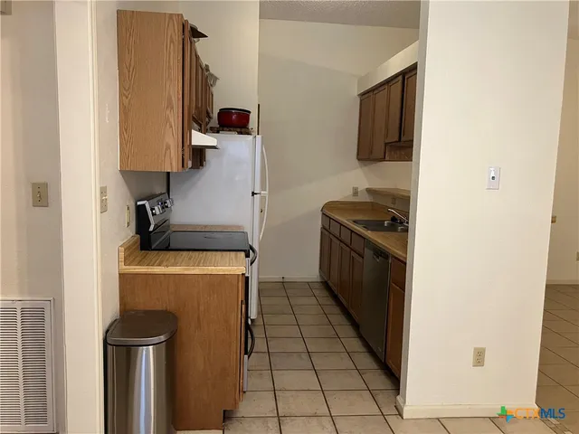 a kitchen with a stove top oven and cabinets