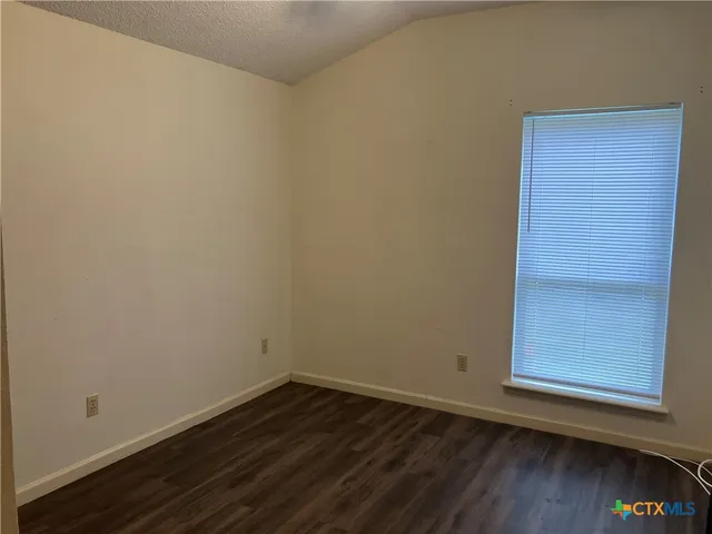 a view of a small space with wooden floor and a window