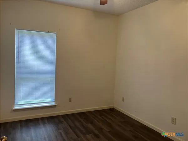 a view of a small space with wooden floor and a window