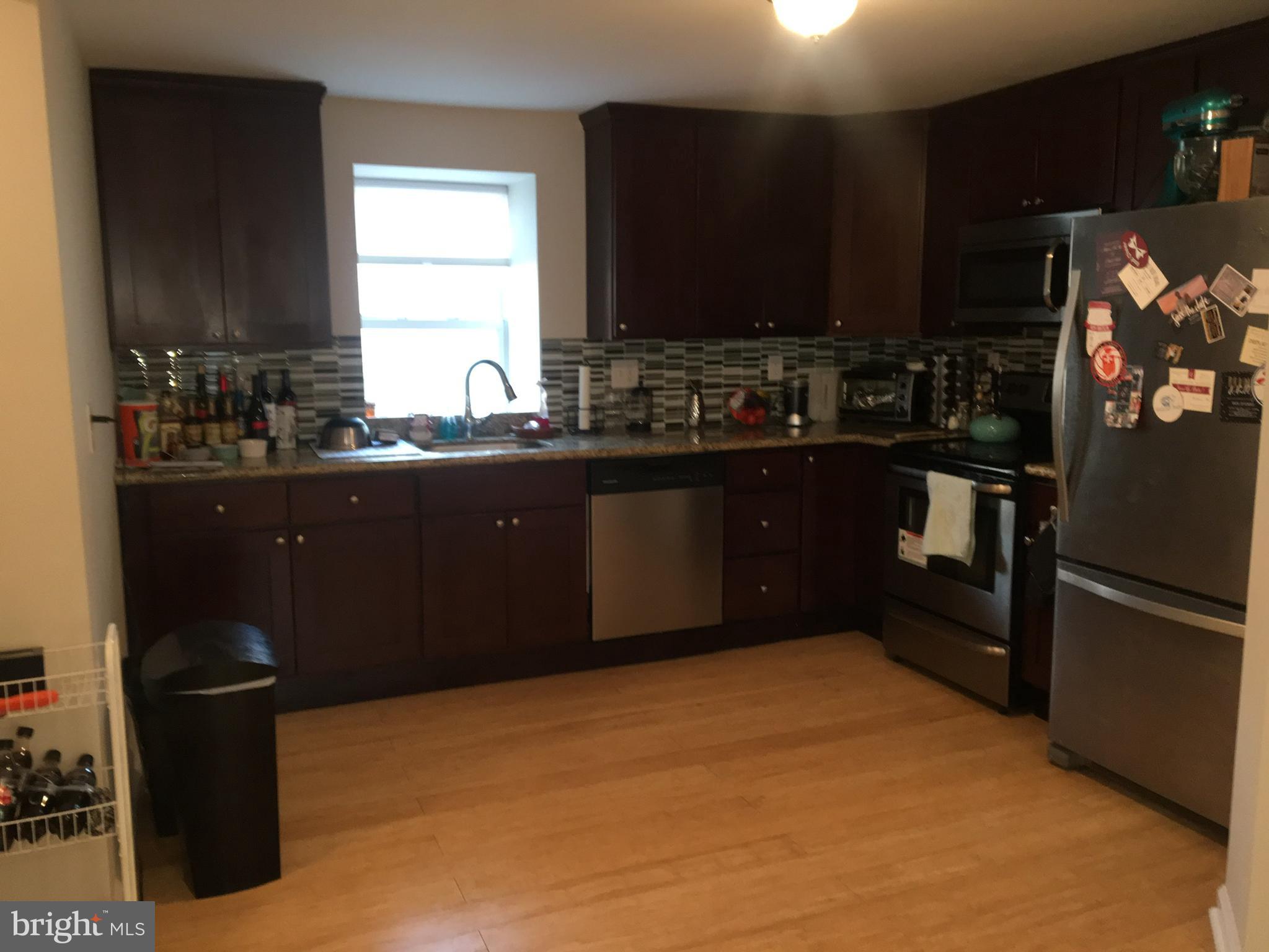 4203 Main Street, Unit 2 Philadelphia, PA 19127 - Photo 6 of 16 a kitchen with granite countertop a refrigerator and a stove top oven