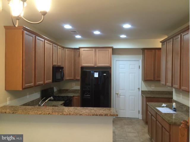13608 Dover Cliffs Place Germantown, MD 20874 - Photo 4 of 26 a kitchen with a refrigerator and a sink