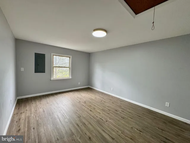 a view of a room with wooden floor and window