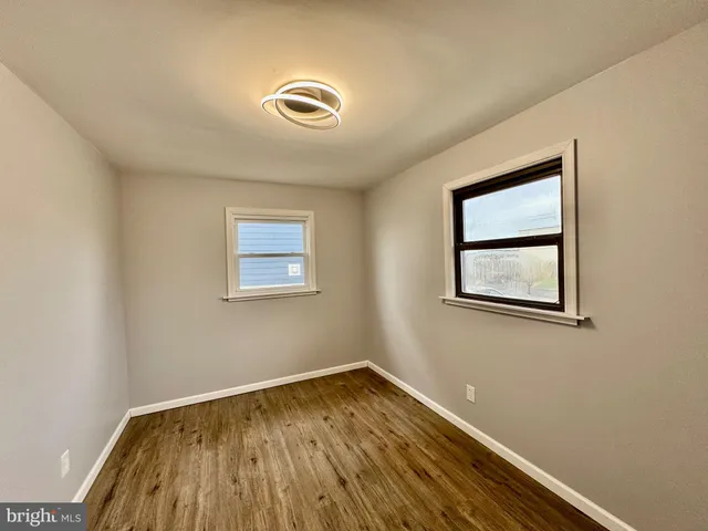 a kitchen with stainless steel appliances granite countertop wooden cabinets a sink a stove a refrigerator and dishwasher with wooden floor