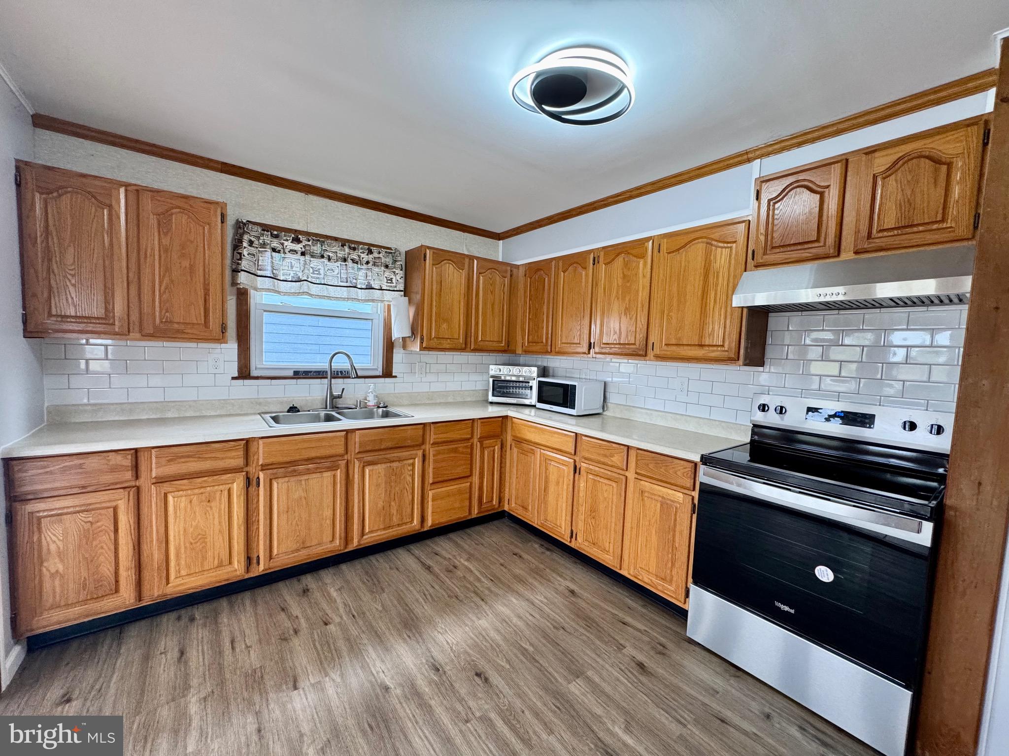 128 Sawyer Road Milford, DE 19963 - Photo 20 of 47 a kitchen with stainless steel appliances granite countertop wooden cabinets a sink a stove a refrigerator and dishwasher with wooden floor