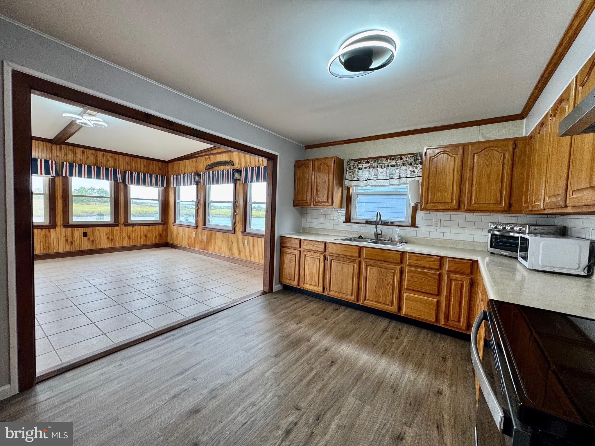 128 Sawyer Road Milford, DE 19963 - Photo 21 of 47 a large kitchen with stainless steel appliances wooden floors wooden cabinets a sink and a window