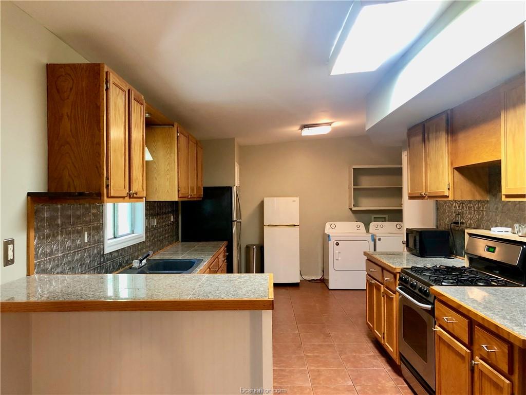 807 Vine Street Bryan, TX 77802 - Photo 6 of 17 a kitchen with stainless steel appliances granite countertop a stove a sink and a refrigerator