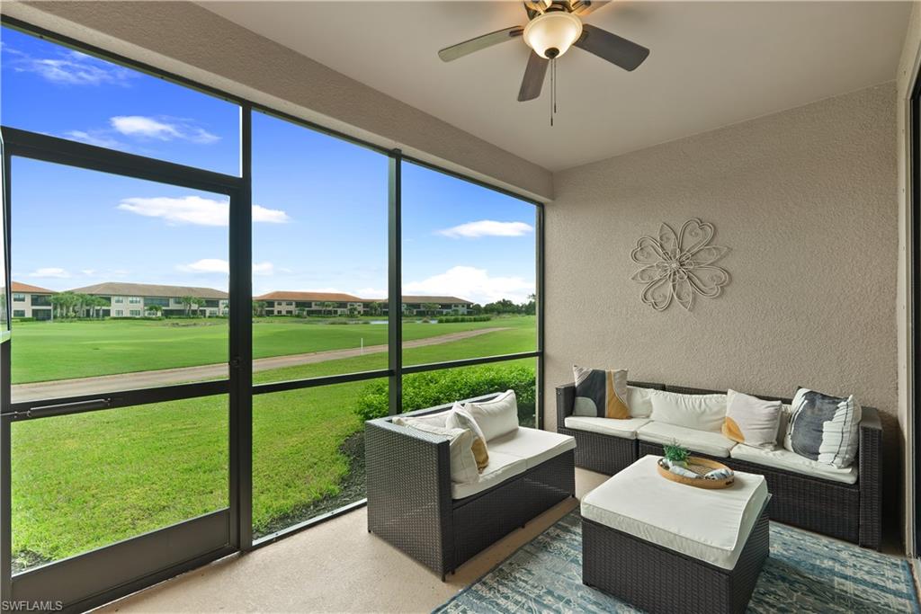 9386 Pocida Court, Unit 103 Naples, FL 34119 - Photo 11 of 43 a living room with furniture and a floor to ceiling window