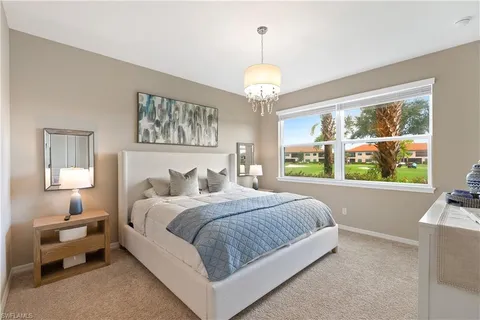 a bedroom with a large bed and a chandelier