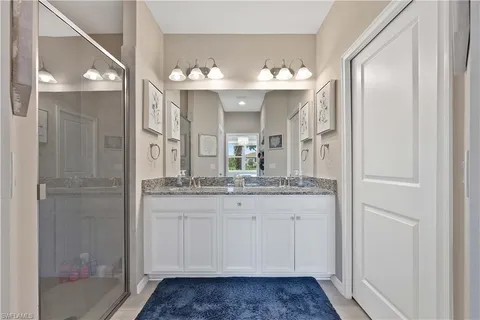 a bathroom with a granite countertop sink a mirror and a shower