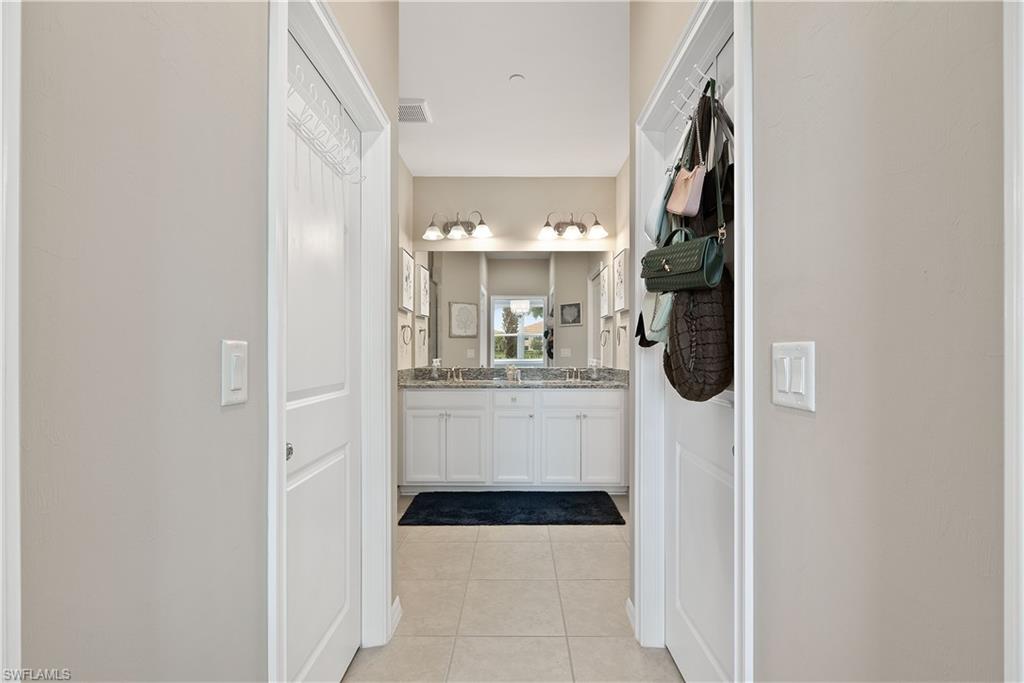 9386 Pocida Court, Unit 103 Naples, FL 34119 - Photo 16 of 43 a bathroom with a sink a mirror and shower