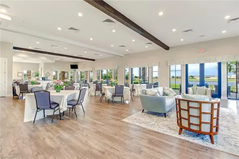 a dining room with furniture wooden floor and a floor to ceiling window