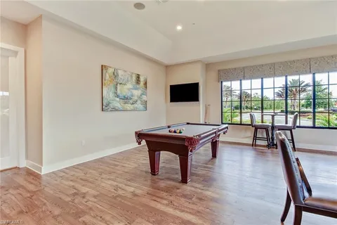 a living room with furniture a flat screen tv and a floor to ceiling window