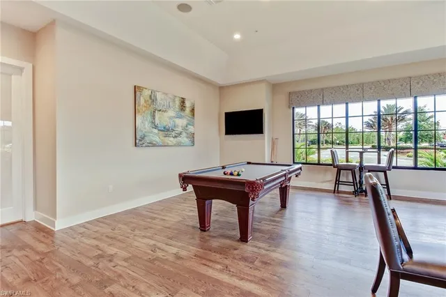 a living room with furniture a flat screen tv and a floor to ceiling window