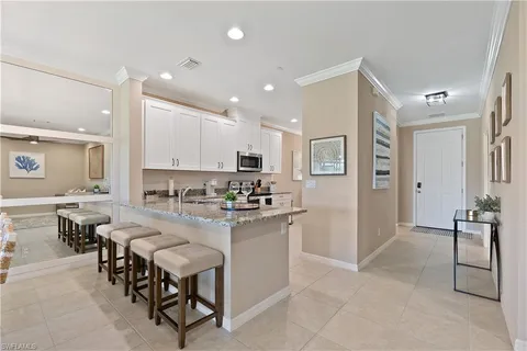 a kitchen with refrigerator and chairs