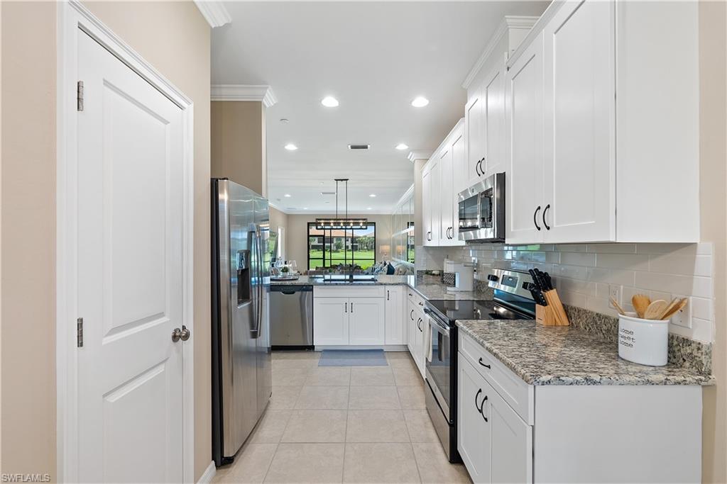 9386 Pocida Court, Unit 103 Naples, FL 34119 - Photo 8 of 43 a kitchen with a sink a refrigerator and cabinets