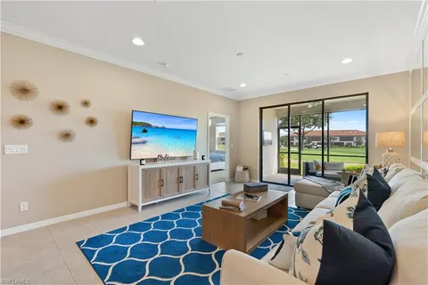a living room with furniture a flat screen tv and a large window