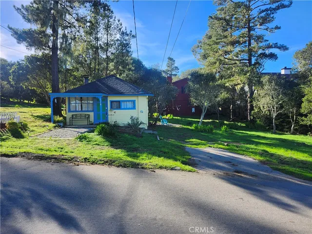 a front view of a house with a yard and trees