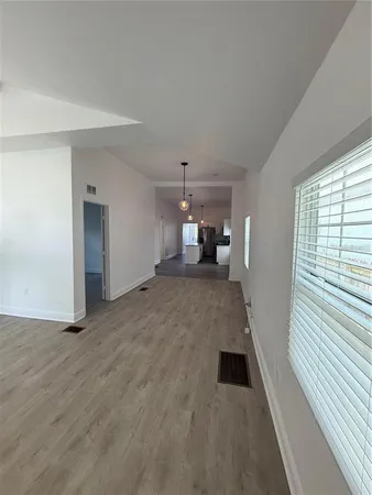 a large kitchen with cabinets wooden floor and stainless steel appliances