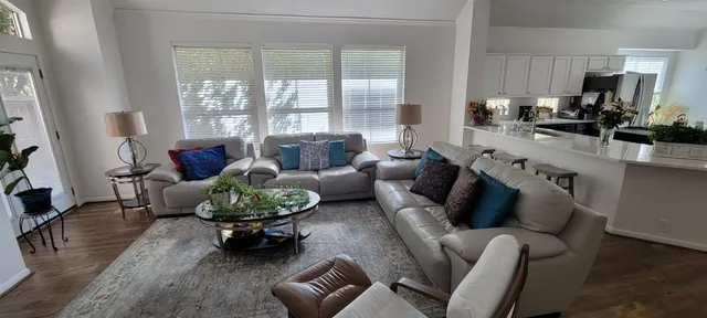 a living room with furniture fireplace and a large window