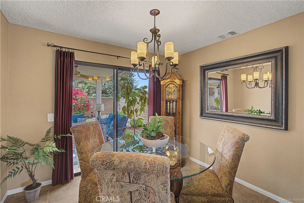 1129 Vía Nice Redlands, CA 92374 - Photo 14 of 23 a dining room with furniture a large window and a chandelier