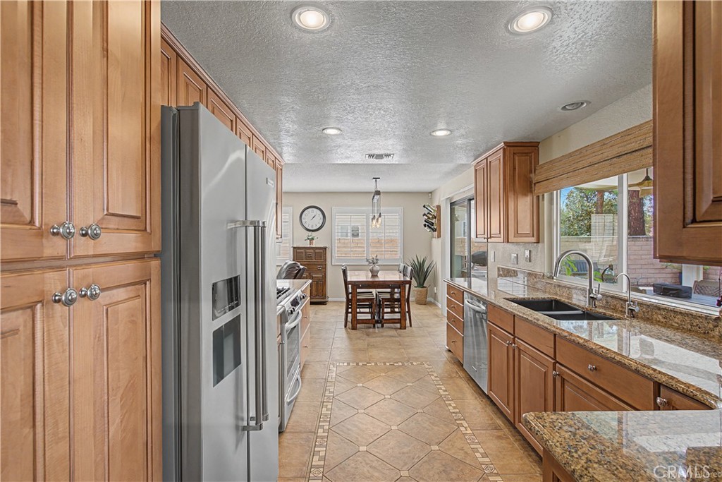 1129 Vía Nice Redlands, CA 92374 - Photo 20 of 23 a kitchen with stainless steel appliances granite countertop a sink and cabinets