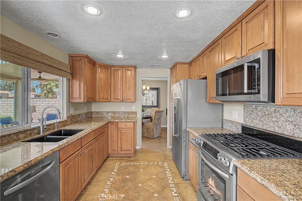 1129 Vía Nice Redlands, CA 92374 - Photo 8 of 23 a kitchen with a sink stove top oven and refrigerator