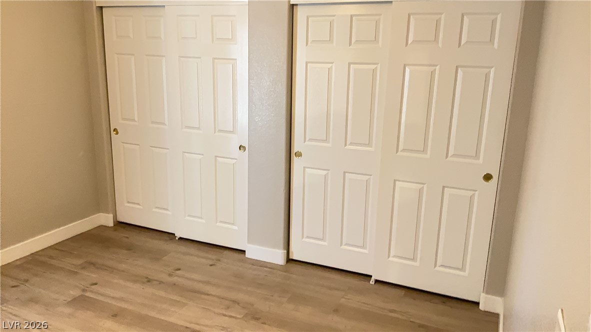 830 Carnegie Street, Unit 1024 Henderson, NV 89052 - Photo 17 of 27 Unfurnished bedroom with two closets and light wood-type flooring