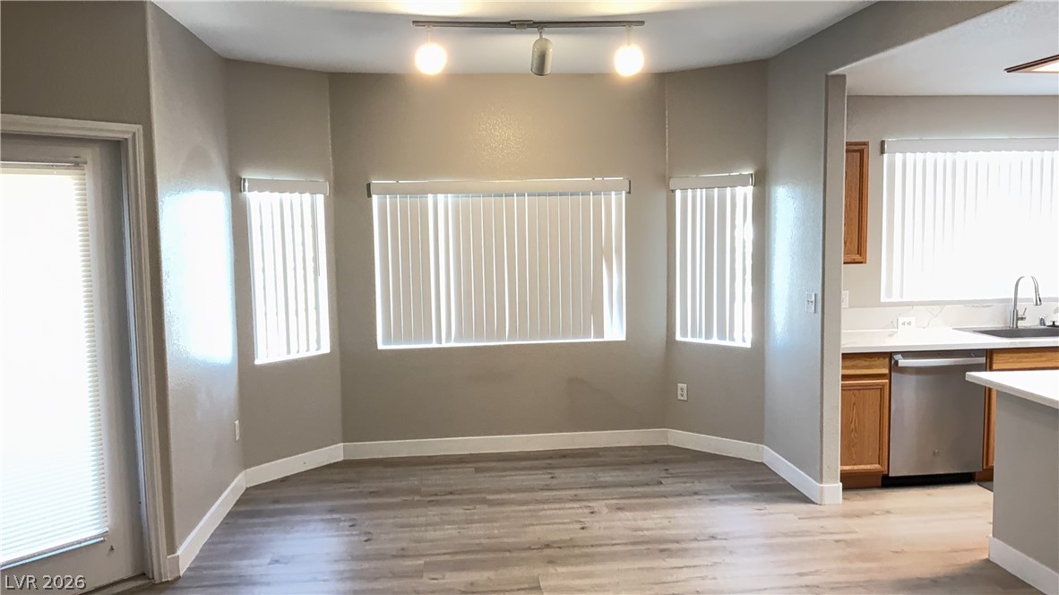 830 Carnegie Street, Unit 1024 Henderson, NV 89052 - Photo 4 of 27 Kitchen with light countertops, dishwasher, healthy amount of natural light, light wood-style flooring, and rail lighting