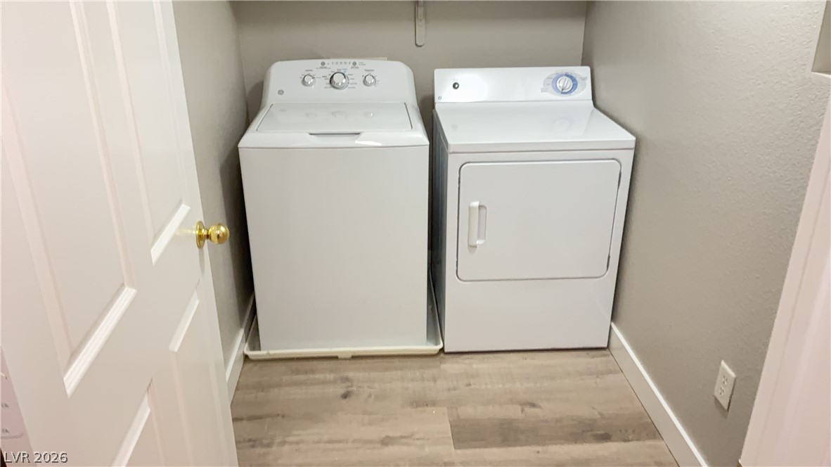 830 Carnegie Street, Unit 1024 Henderson, NV 89052 - Photo 9 of 27 Laundry room with washer and dryer, light wood-style flooring, and a textured wall