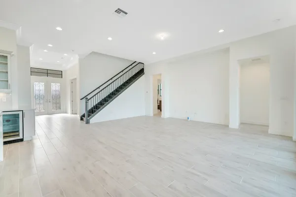 a large white kitchen with kitchen island a sink stainless steel appliances and cabinets