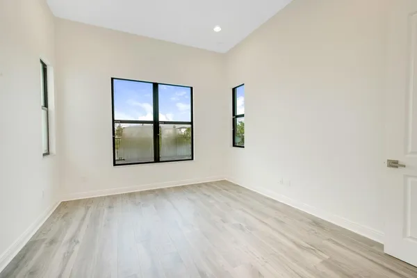 an empty room with wooden floor and mirror