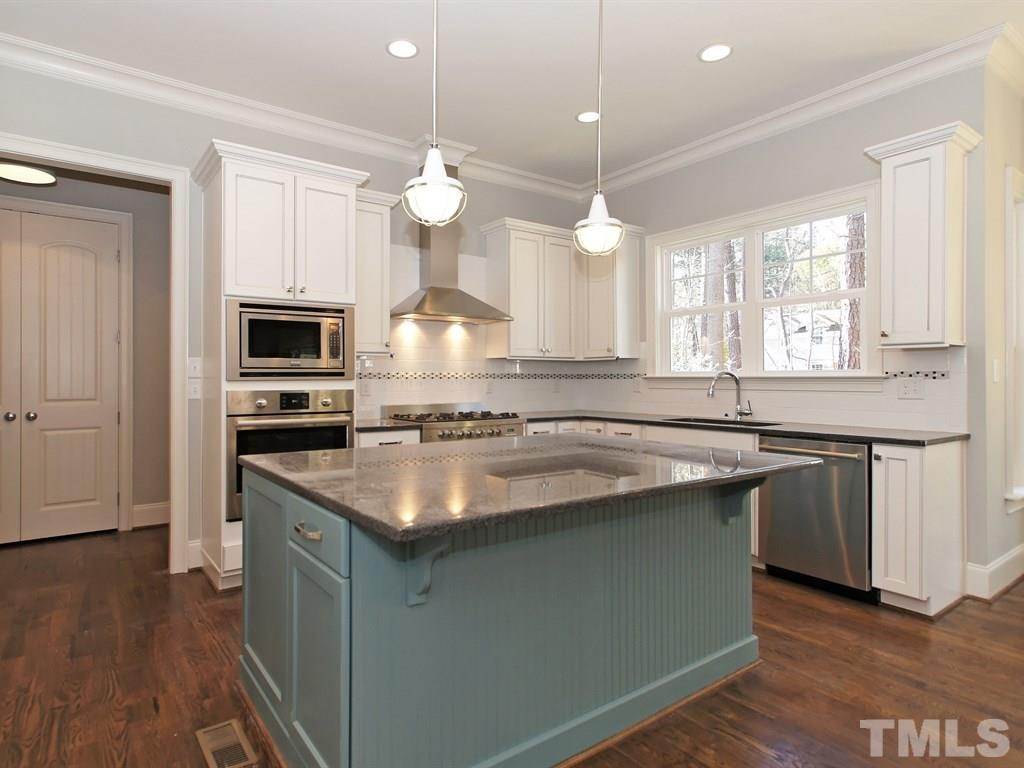 6415 Rosny Road Raleigh, NC 27613 - Photo 12 of 25 a kitchen with stainless steel appliances granite countertop a sink a stove and a wooden floors