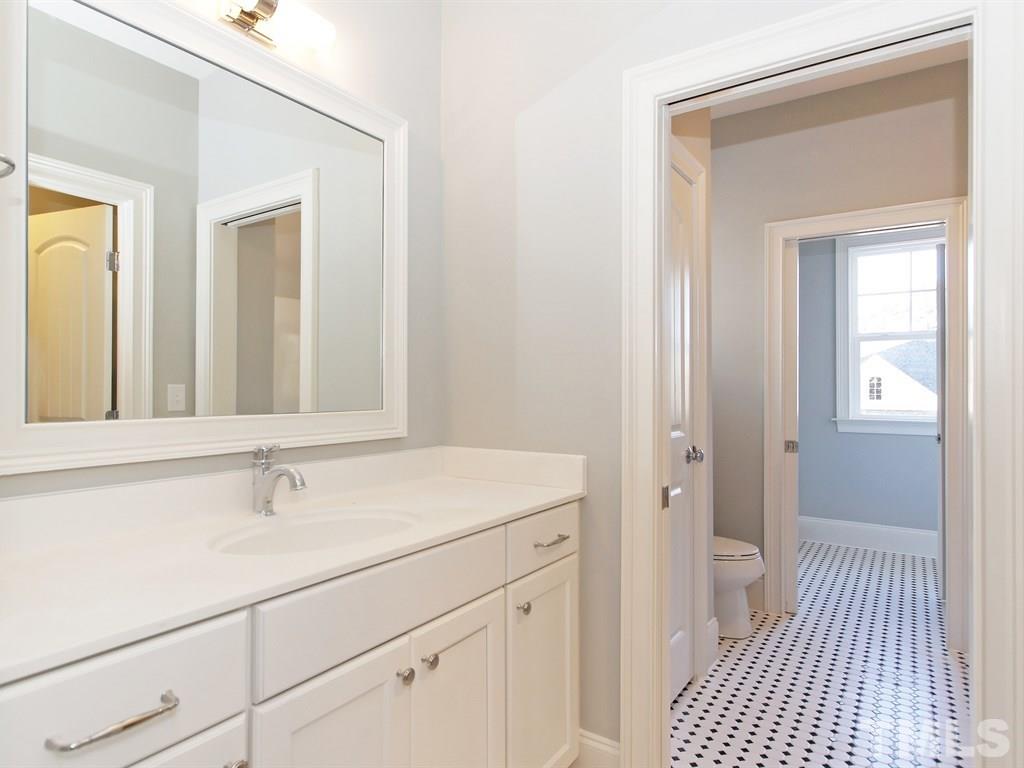 6415 Rosny Road Raleigh, NC 27613 - Photo 20 of 25 a bathroom with a sink and a mirror