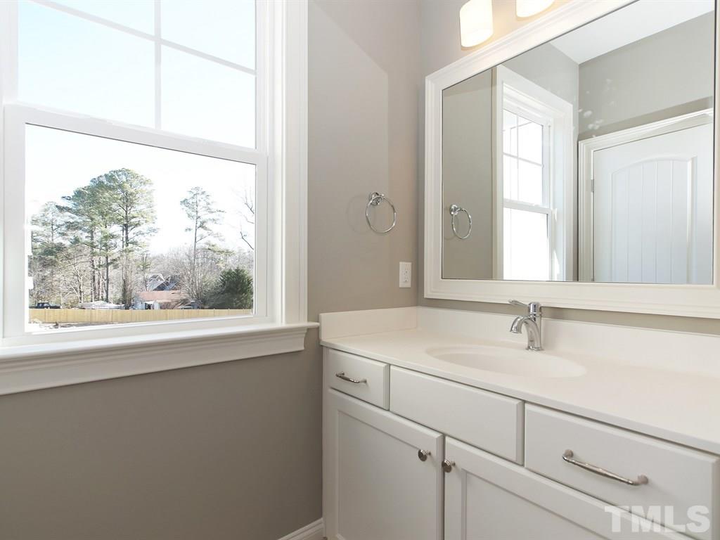 6415 Rosny Road Raleigh, NC 27613 - Photo 23 of 25 a bathroom with a sink and a large mirror