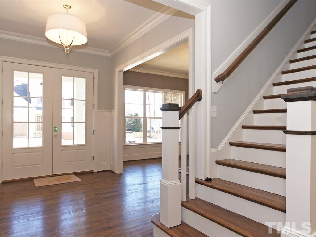 6415 Rosny Road Raleigh, NC 27613 - Photo 3 of 25 a view of an empty room with wooden floor and fan