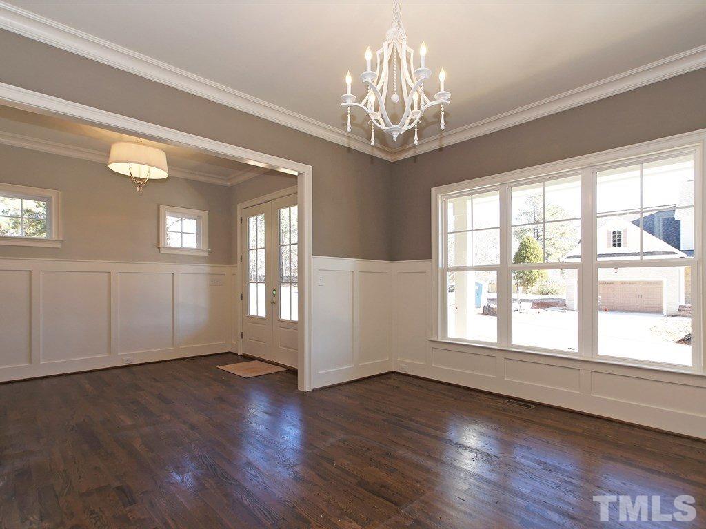 6415 Rosny Road Raleigh, NC 27613 - Photo 4 of 25 a view of an empty room with wooden floor and a window