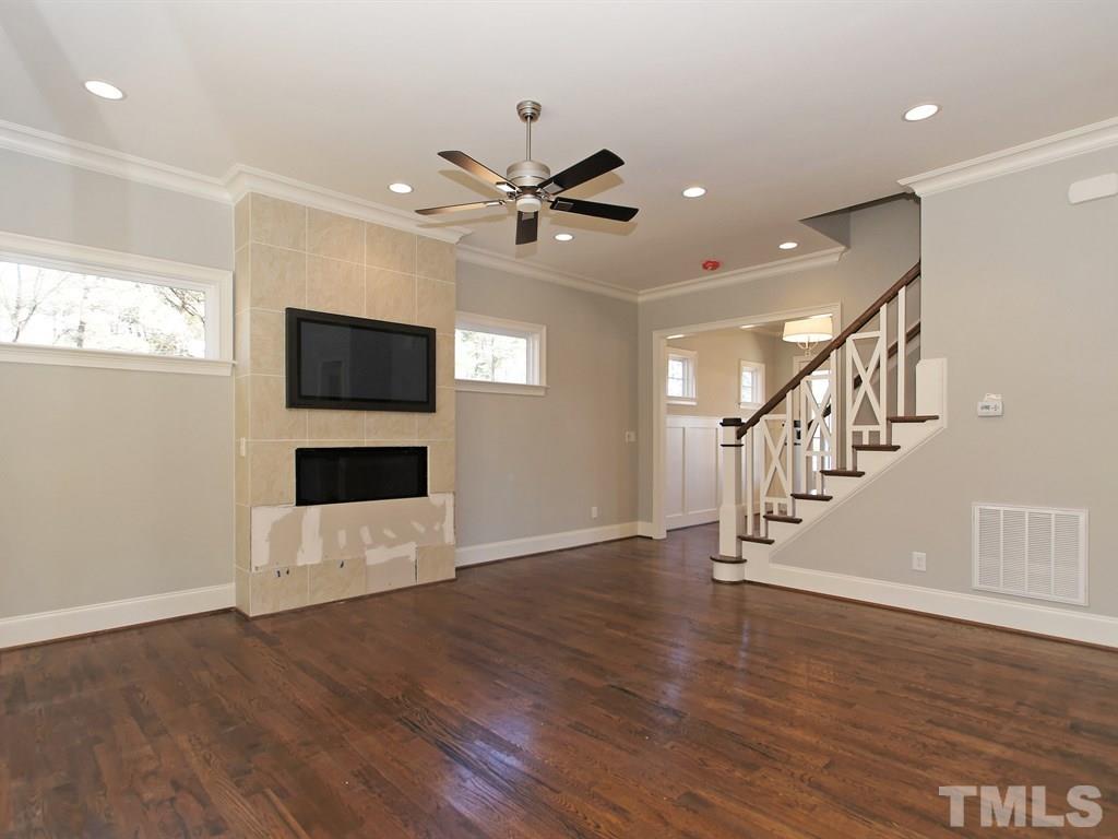 6415 Rosny Road Raleigh, NC 27613 - Photo 7 of 25 a view of a livingroom with wooden floor and a ceiling fan