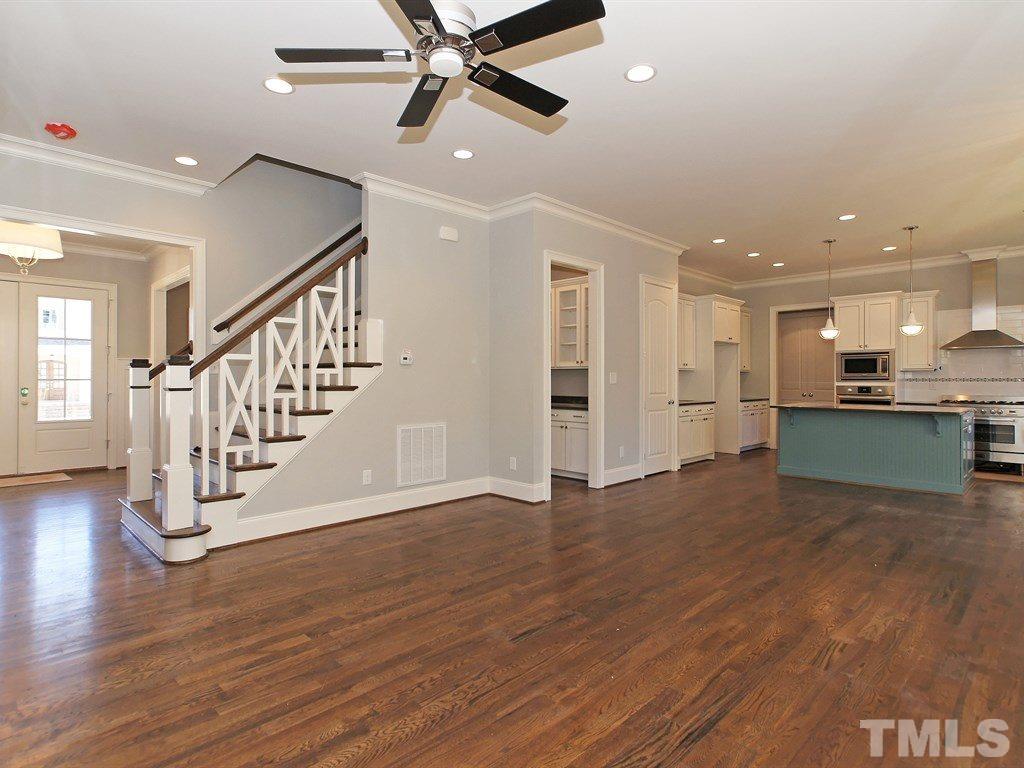 6415 Rosny Road Raleigh, NC 27613 - Photo 8 of 25 a view of an empty room wooden floor and a kitchen