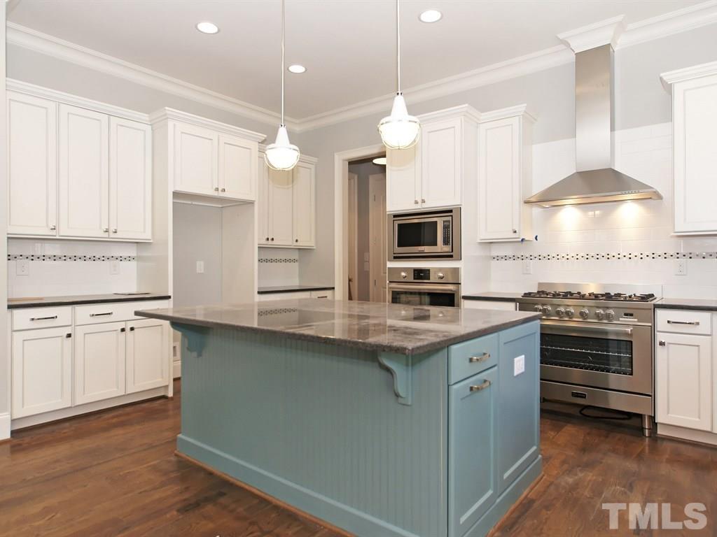6415 Rosny Road Raleigh, NC 27613 - Photo 10 of 25 a kitchen with stainless steel appliances granite countertop a stove a sink and a refrigerator