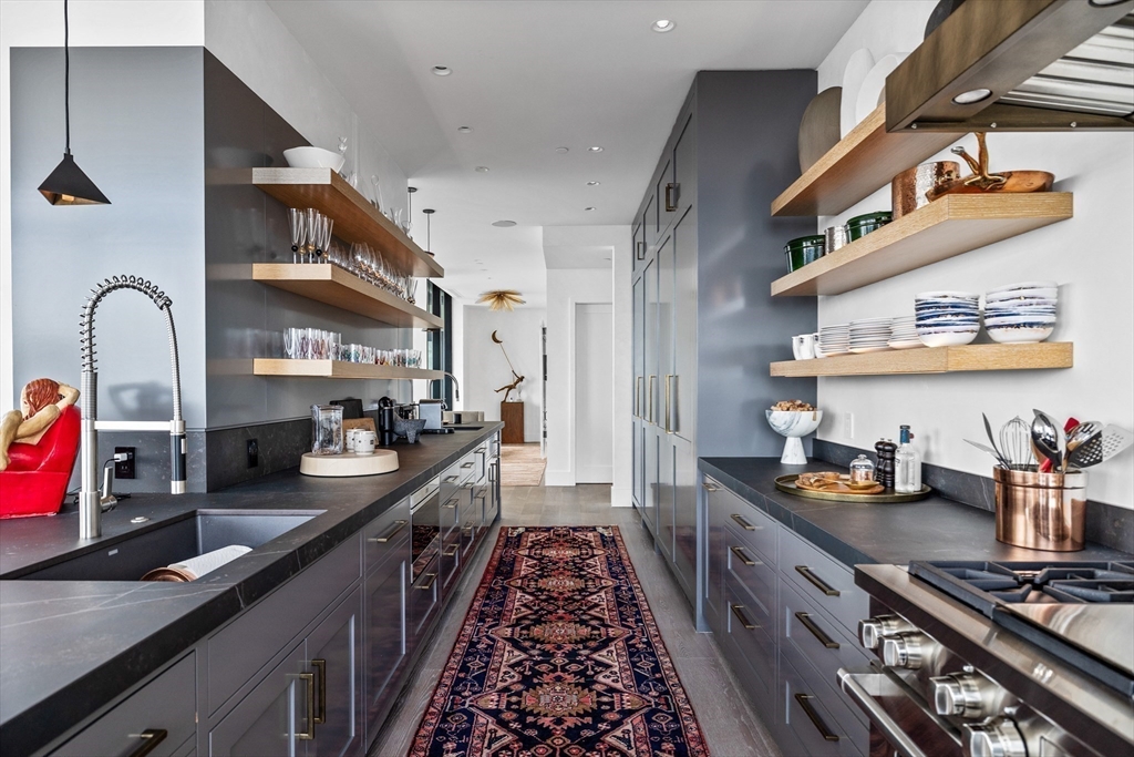 1 Franklin Street, Unit PH3E Boston, MA 02110 - Photo 12 of 42 a kitchen with lots of counter top space and stainless steel appliances