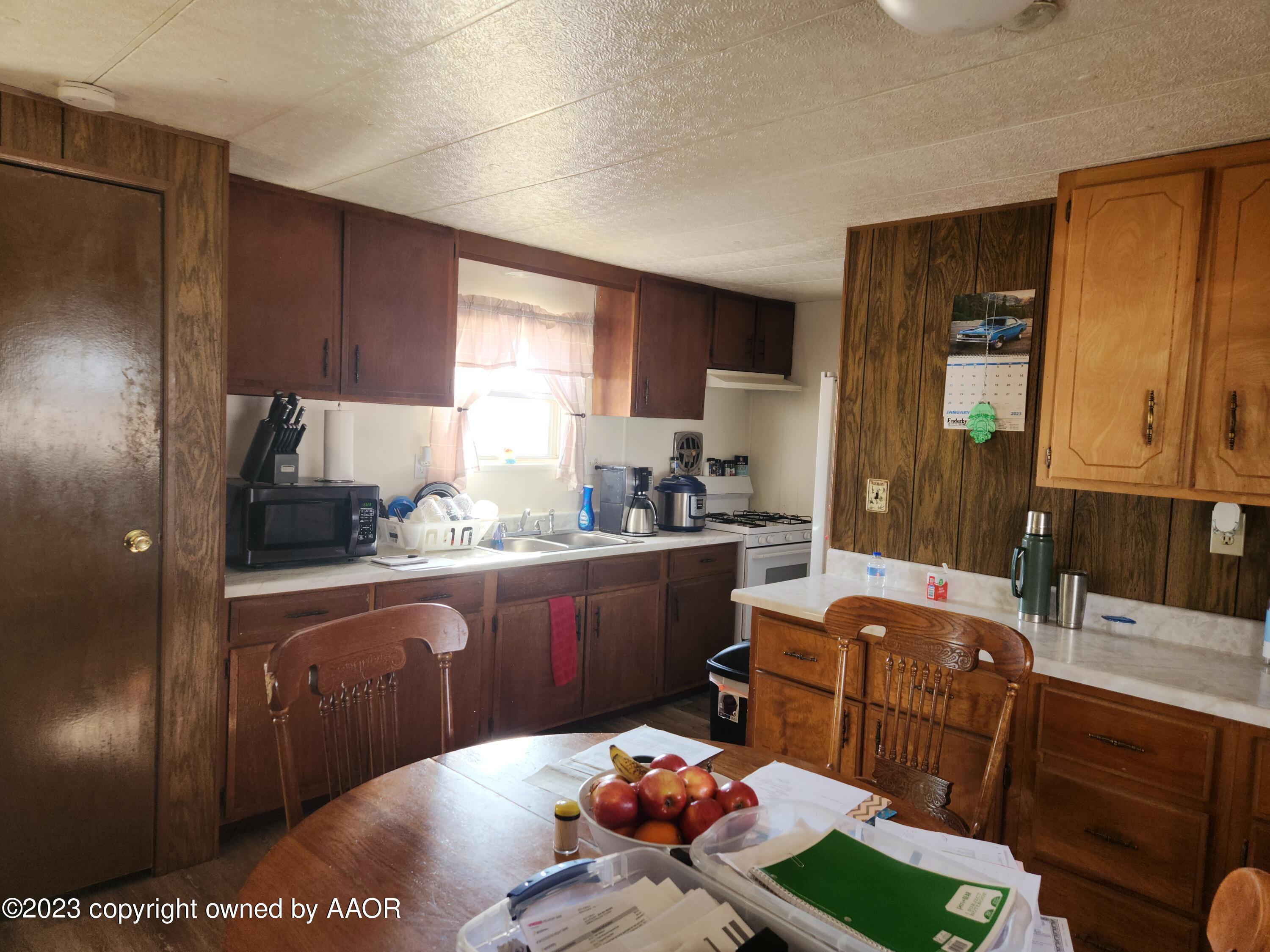 304 Collins Street Claude, TX 79019 - Photo 5 of 11 a kitchen with a sink refrigerator and cabinets